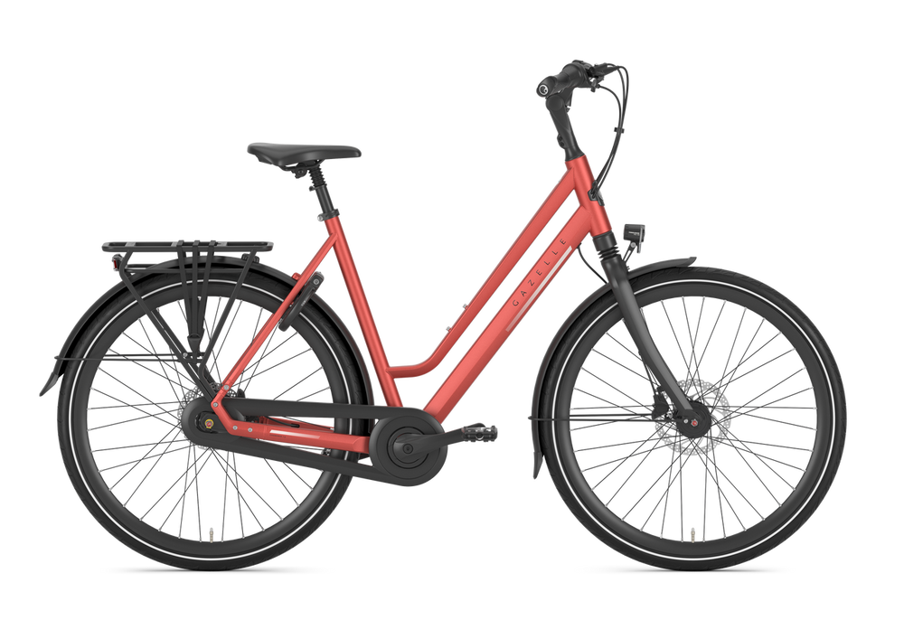 Billede af Gazelle Chamonix C8 Dame cykel i metallic orange farve, der står på en græsplæne med en blå himmel i baggrunden.