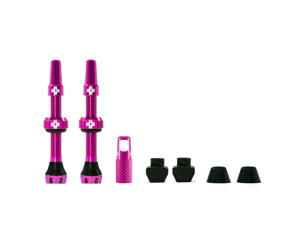 Mucoff Tubeless Valve Kit V. 2.0 med to ventiler og tilbehør til tubeless cykeldæk, præsenteret på en hvid baggrund.