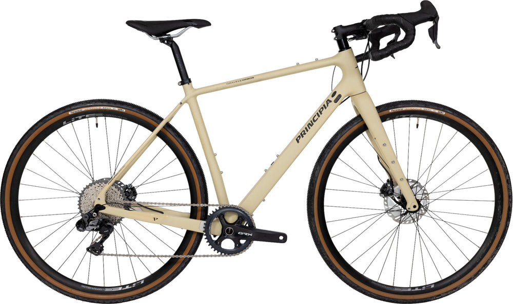 Billede af Principia Gravel Carbon cykel i mat sandfarve, designet til gravel riding med letvægts carbonramme og moderne geometri.
