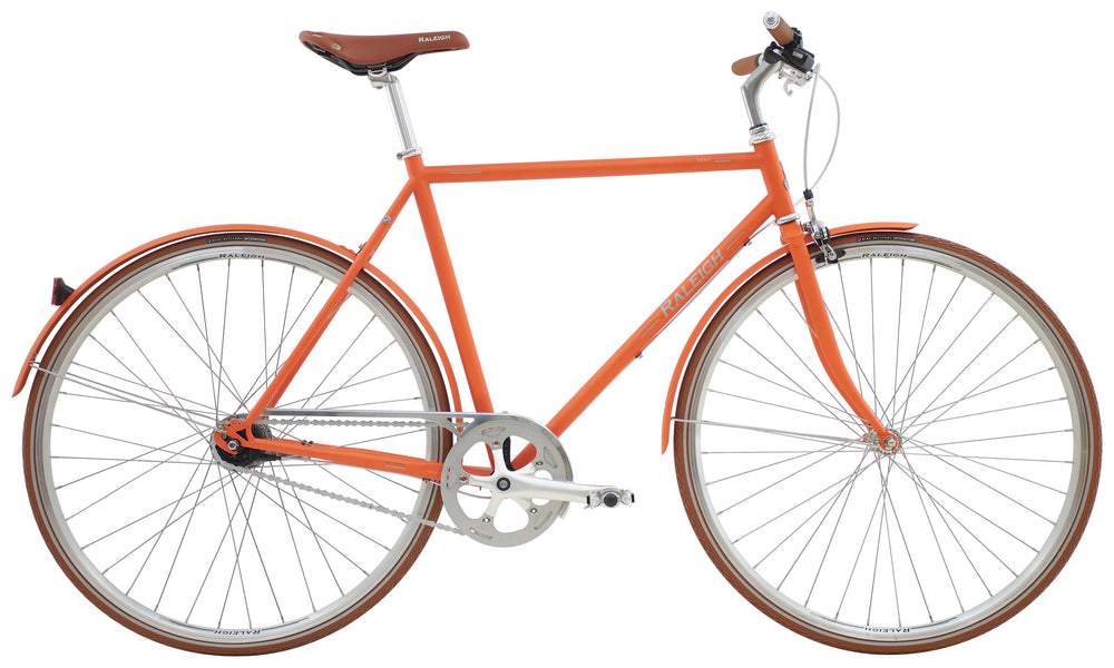 Mat orange Raleigh Kent herrecykel med 7 gear, stående på en græsplæne.