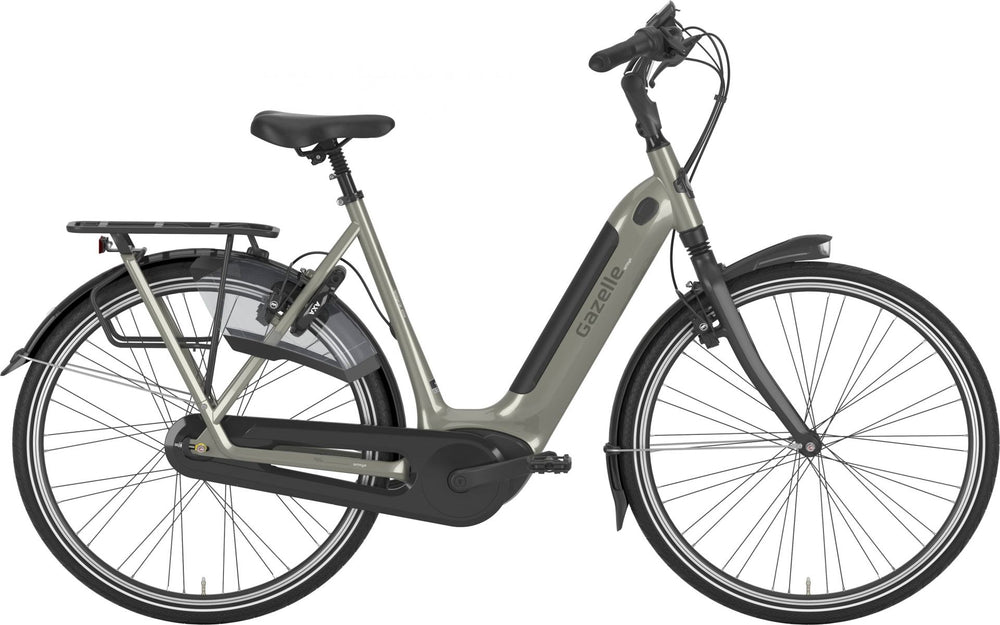 Gazelle Arroyo C8 HMB Elite cykel i farven Warm Grey, stående på en vej med en naturbaggrund. Cyklen har en elegant design med komfortable funktioner og en opretstående kørestilling.