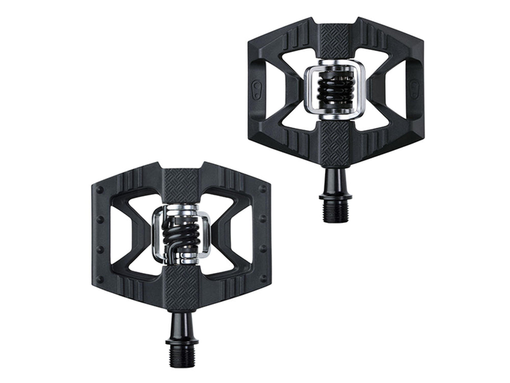 Billedet viser Crankbrothers Double Shot 1 pedaler, der har en robust og funktionel design. Pedalerne er udstyret med en platform og klipsystem, der giver både komfort og effektivitet til cyklister. Farven er sort, og de er ideelle til mountainbiking og terræncykling.