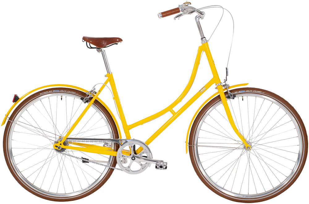 Cykel ved navn "Bike by Gubi Dame 8 Gear Gul" med gul ramme og sorte dæk, stående på asfalt.