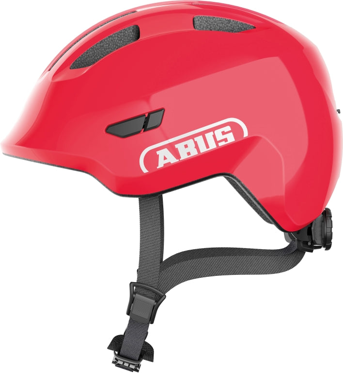 Rød cykelhjelm Abus Smiley 3.0 med skinnende overflade, justerbar rem og ventilationshuller.
