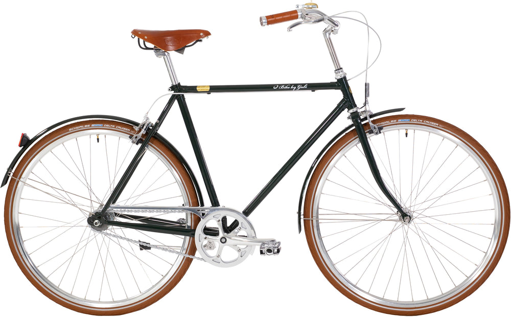 Cykel med 7 gear i grøn farve fra Gubi, herremodel, stående på asfalt med en baggrund af grønne træer.