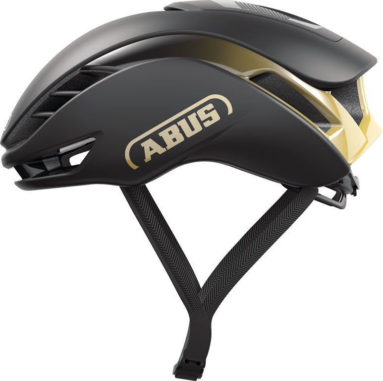 Sort og guld Abus GameChanger 2.0 hjelm med aerodynamisk design, set fra siden mod en hvid baggrund.