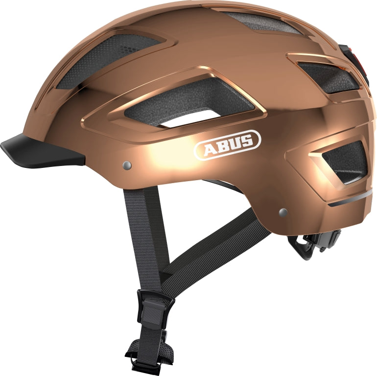 Cykelhjelm Abus Hyban 2.0 i krom rose farve, set fra siden med justerbar rem og ventilationshuller.