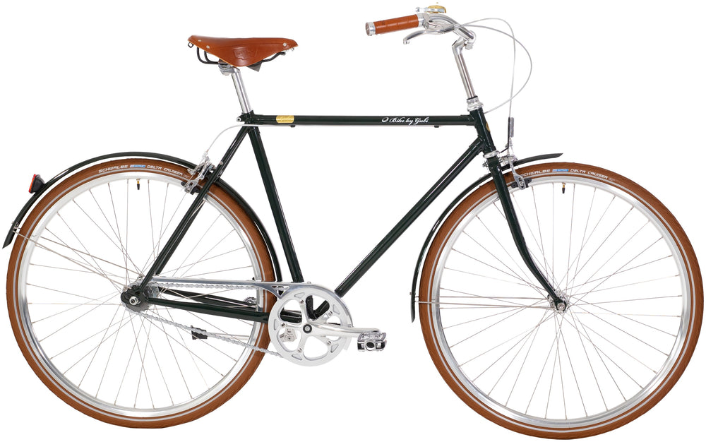 Cykel i britisk racinggrøn med 8 gear, Bike by Gubi Herre 2020, står på asfalt med grønne træer i baggrunden.