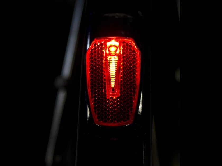 Cykellygte Bike Attitude Vena XB monteret på bagskærm med batteri, set fra siden på en cykel.